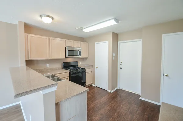 a kitchen with wooden cabinets and stainless steel appliances