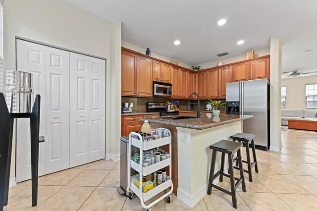 a kitchen with stainless steel appliances granite countertop a refrigerator and a stove top oven