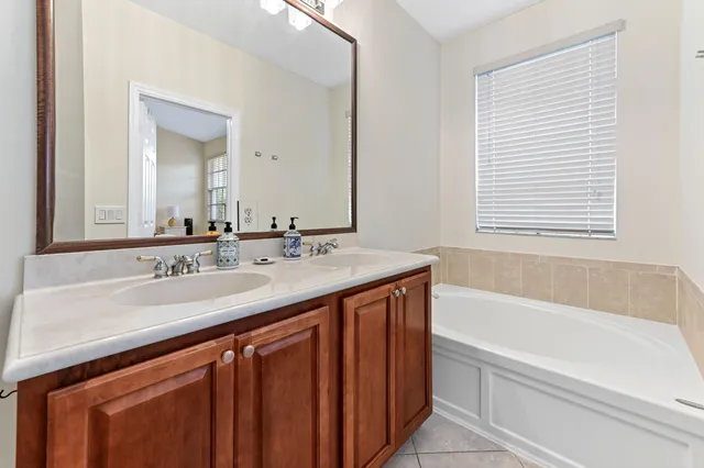 a bathroom with a granite countertop sink and a bathtub