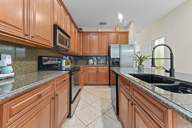 a kitchen with stainless steel appliances granite countertop a sink and cabinets