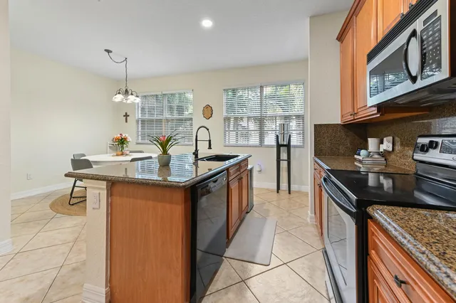 a kitchen with stainless steel appliances granite countertop a sink stove and cabinets