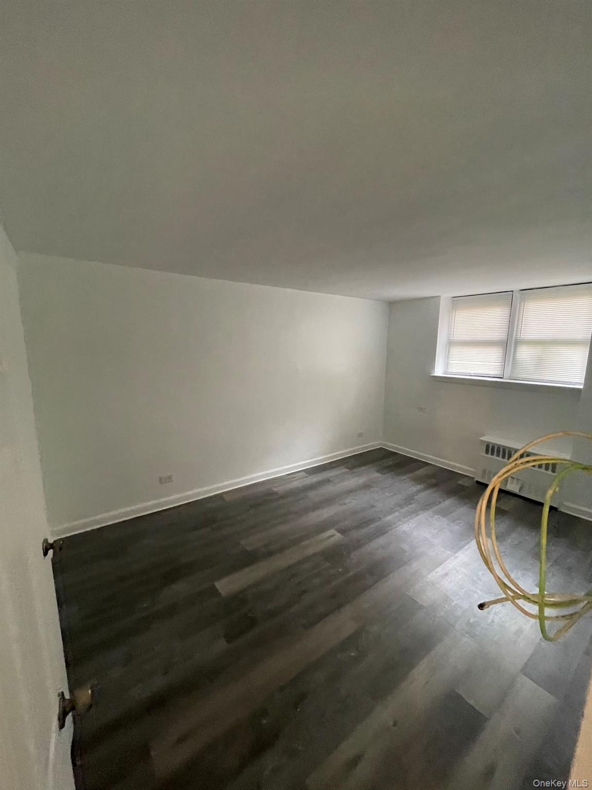 83-25 Vietor Avenue, Unit 1D Queens, NY 11373 - Photo 3 of 7 an empty room with wooden floor and windows