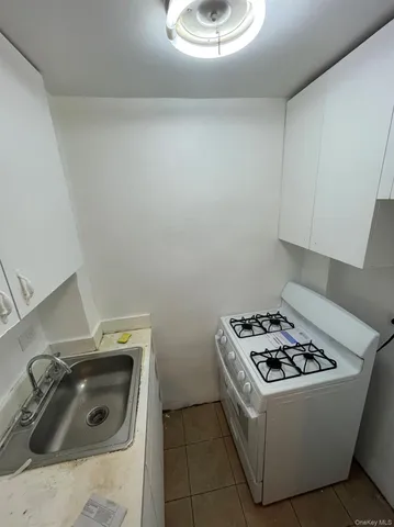 a white stove top oven sitting inside of a kitchen