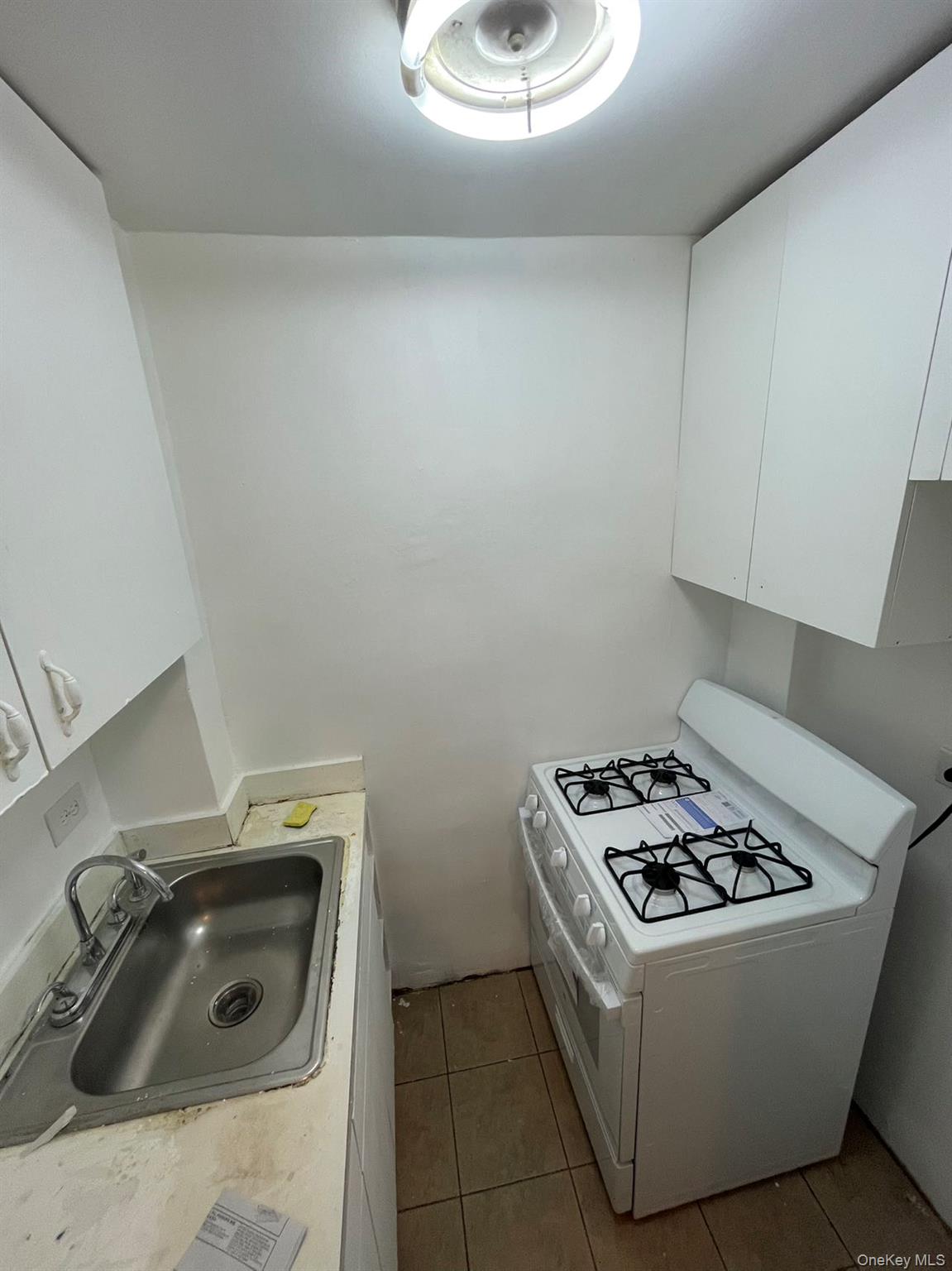 83-25 Vietor Avenue, Unit 1D Queens, NY 11373 - Photo 4 of 7 a white stove top oven sitting inside of a kitchen