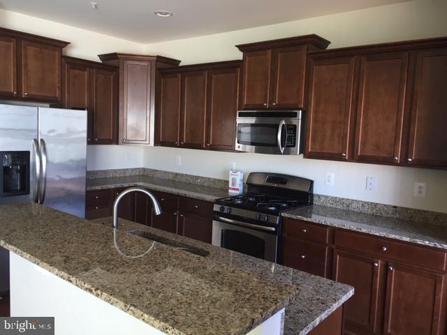 8708 Sagebrush Lane Laurel, MD 20724 - Photo 2 of 29 a kitchen with granite countertop wooden cabinets and stainless steel appliances