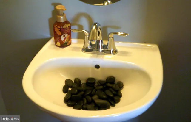 a bathroom with a granite countertop toilet and a sink