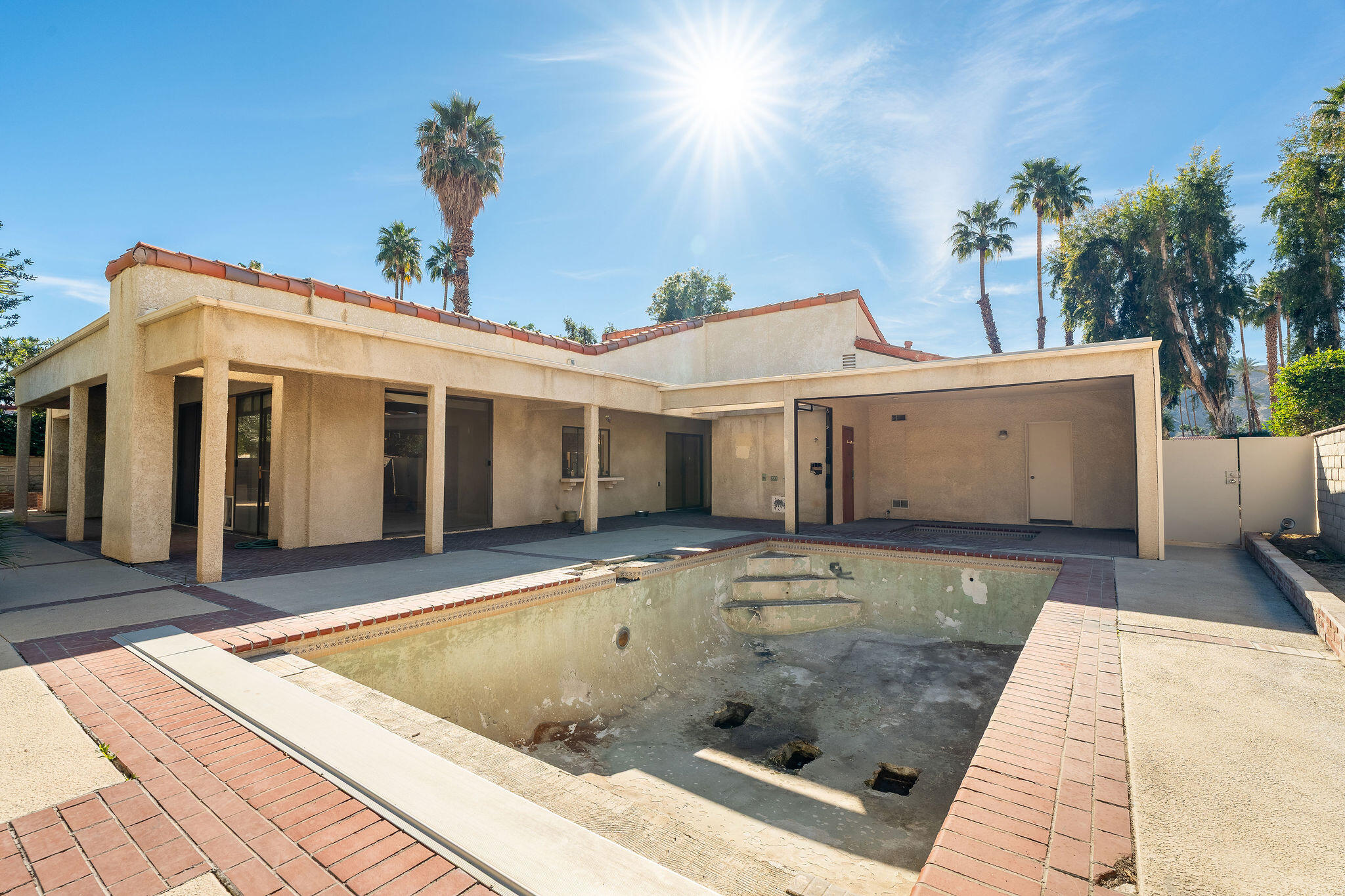 62 Sierra Madre Way Rancho Mirage, CA 92270 - Photo 36 of 46 a view of a white house with a small yard and potted plants