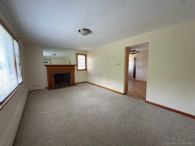 an empty room with fireplace and a window