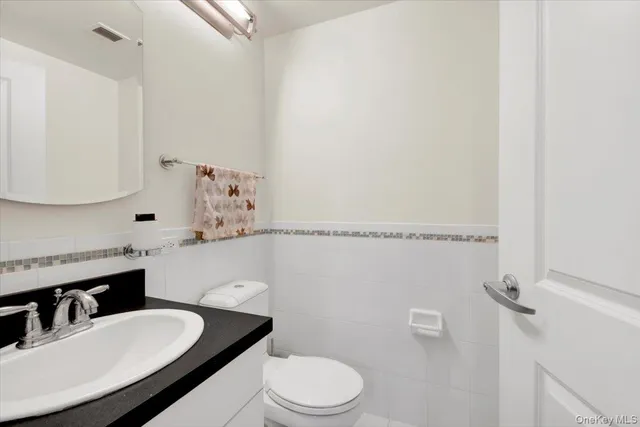 a bathroom with a sink vanity mirror and toilet