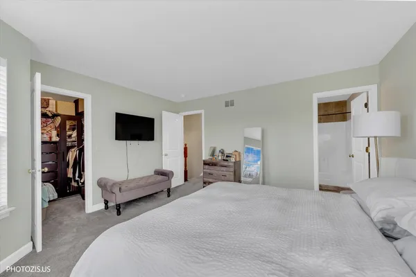 a spacious bedroom with a bed and a flat screen tv