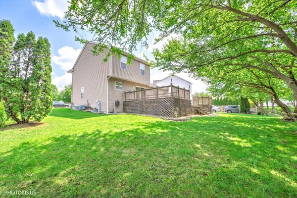 a view of a house with a yard and a large tree