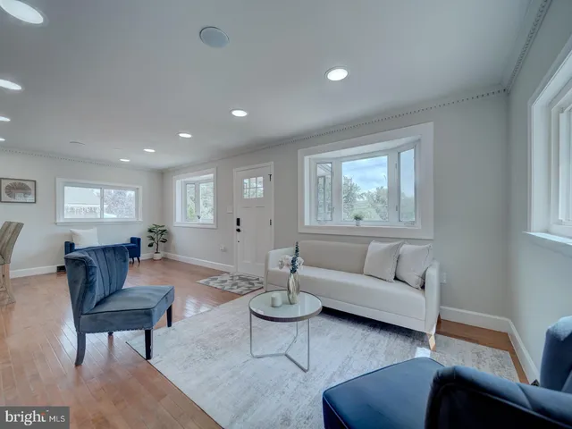 a kitchen with stainless steel appliances kitchen island granite countertop a refrigerator a stove a sink dishwasher and a dining table with wooden floor