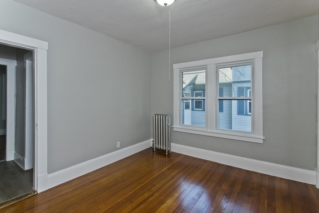 52-54 Draper Street Springfield, MA 01108 - Photo 14 of 31 a view of an empty room with wooden floor and a window