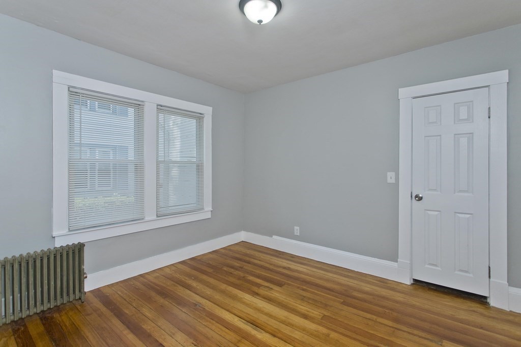 52-54 Draper Street Springfield, MA 01108 - Photo 15 of 31 a view of an empty room with wooden floor and a window