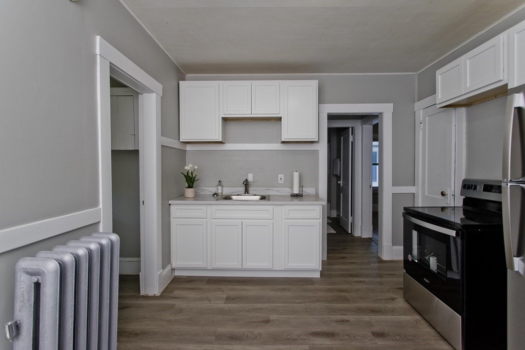 52-54 Draper Street Springfield, MA 01108 - Photo 18 of 31 a kitchen with cabinets and wooden floor