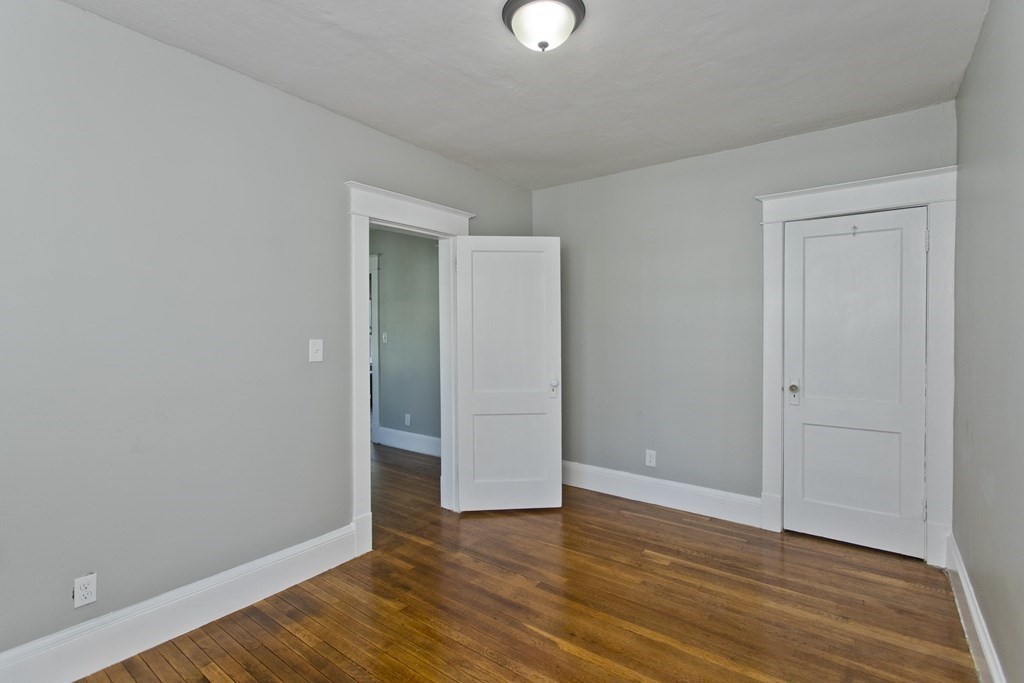 52-54 Draper Street Springfield, MA 01108 - Photo 27 of 31 an empty room with wooden floor and windows