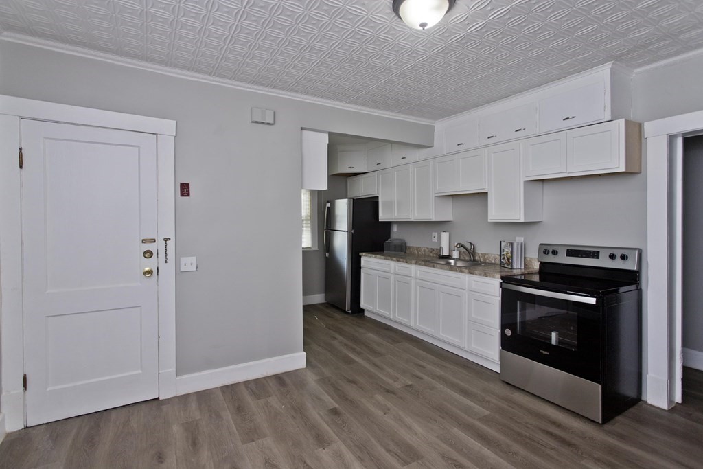 52-54 Draper Street Springfield, MA 01108 - Photo 6 of 31 a kitchen with a refrigerator and a stove top oven