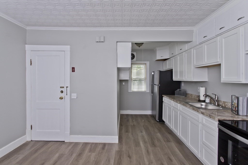 52-54 Draper Street Springfield, MA 01108 - Photo 7 of 31 a kitchen with a sink a refrigerator and cabinets