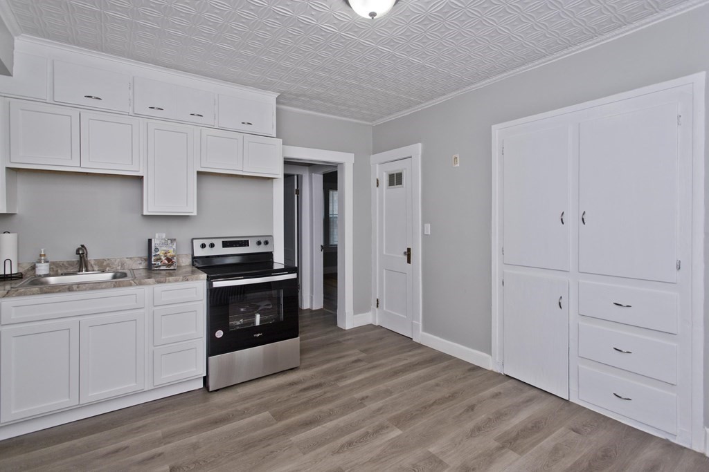52-54 Draper Street Springfield, MA 01108 - Photo 8 of 31 a kitchen with white cabinets and appliances