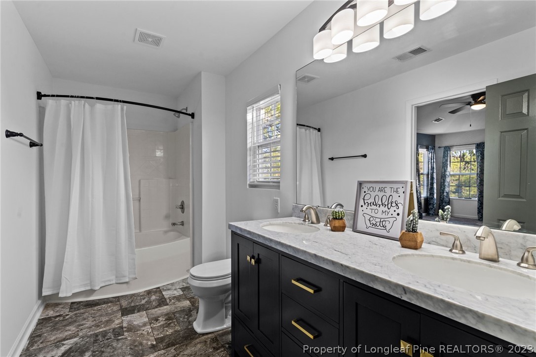 3625 Marshlane Way Raleigh, NC 27610 - Photo 25 of 37 a bathroom with a granite countertop sink a toilet a mirror and shower