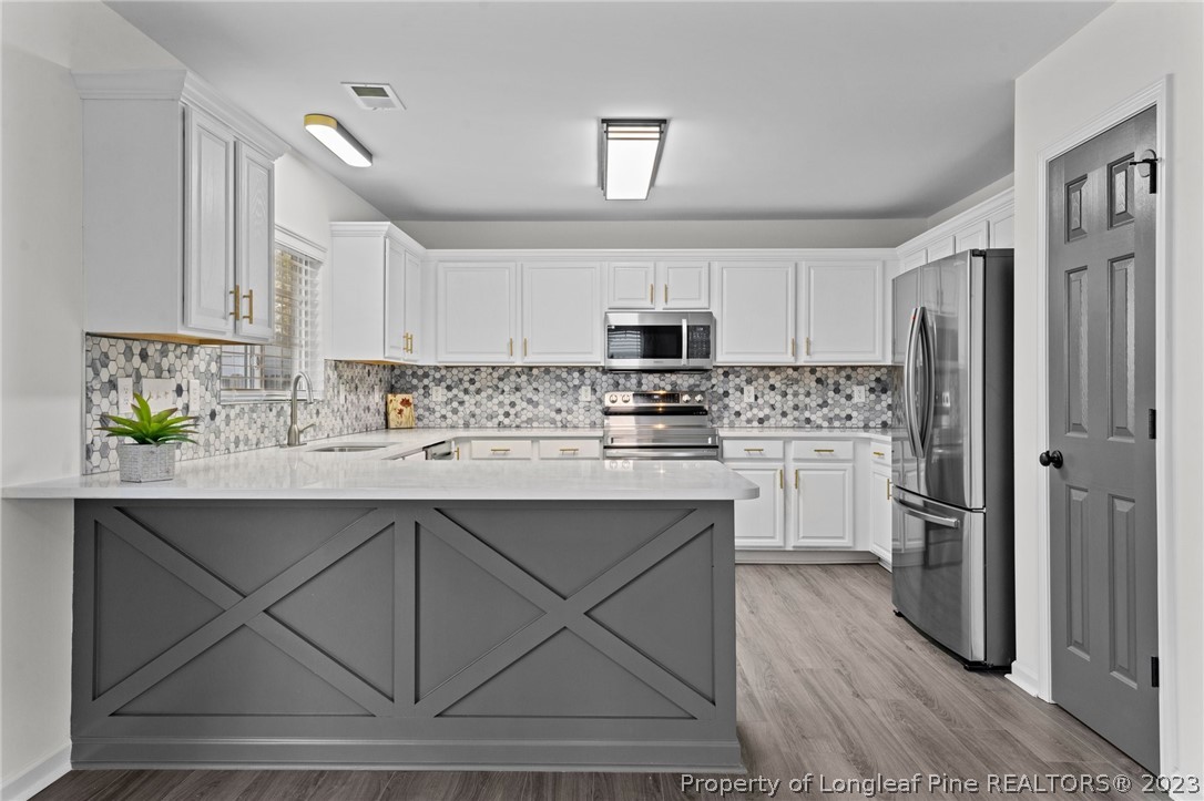 3625 Marshlane Way Raleigh, NC 27610 - Photo 7 of 37 a kitchen with a sink stainless steel appliances and white cabinets