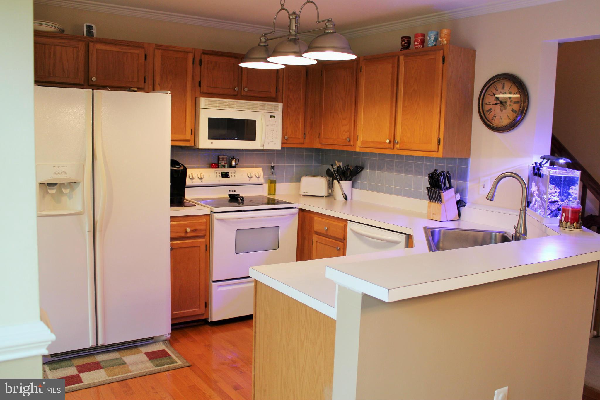 8850 Fox Circle Perry Hall, MD 21128 - Photo 11 of 30 a kitchen with stainless steel appliances a stove a refrigerator a sink a oven with white cabinets and wooden floor