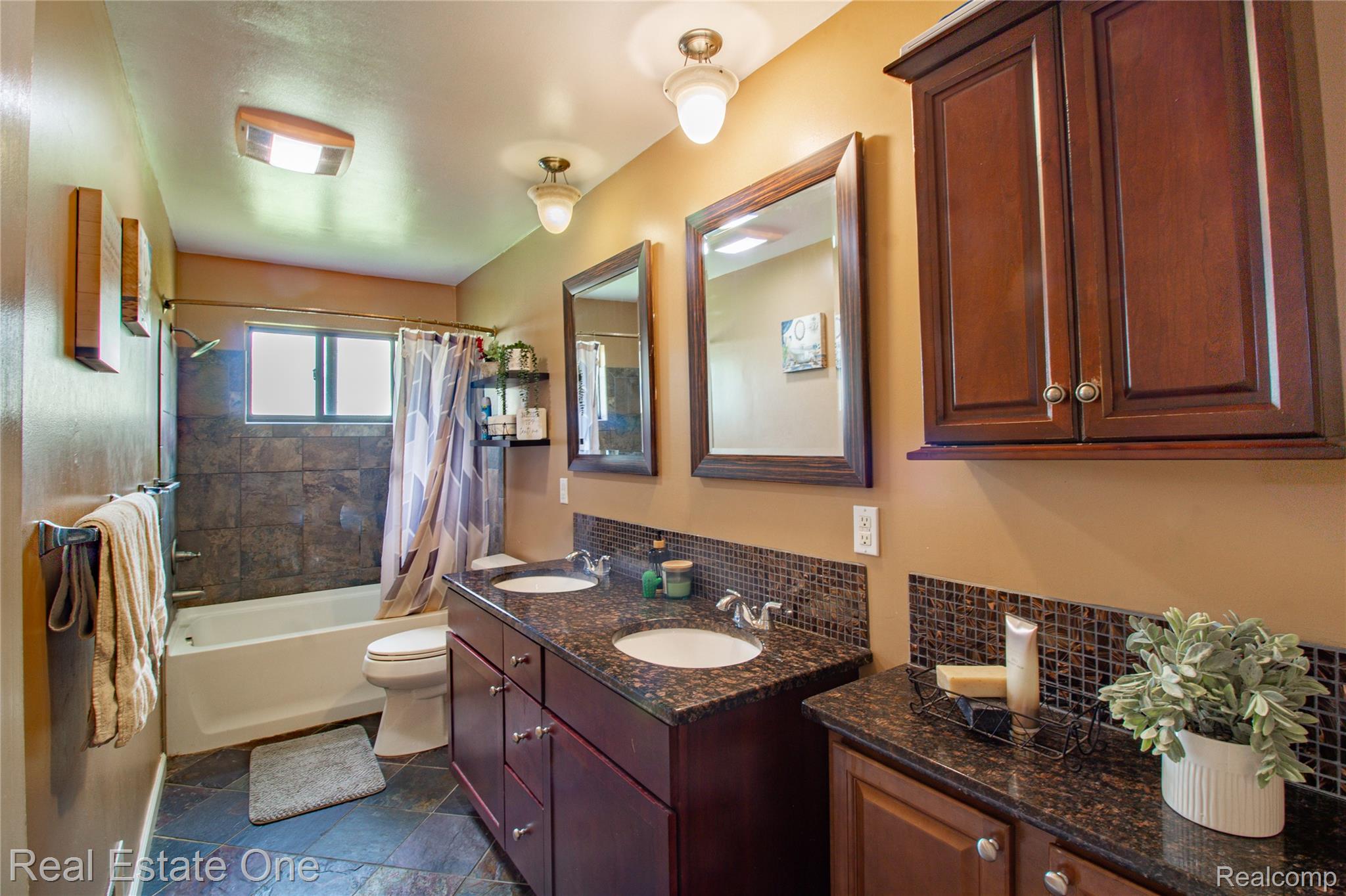 44220 Saltz Road Canton, MI 48187 - Photo 13 of 31 Bathroom featuring a double vanity with dark wood cabinetry, granite-finish countertops, and mosaic tile backsplashes
