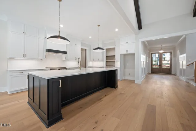 a kitchen with a wooden floor and cabinets