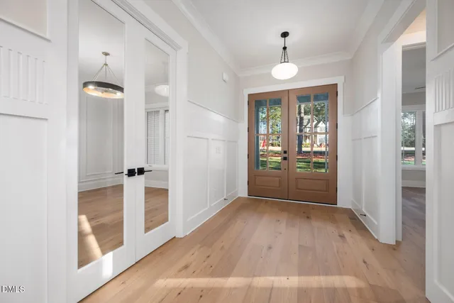 an empty room with wooden floor ceiling fan and windows
