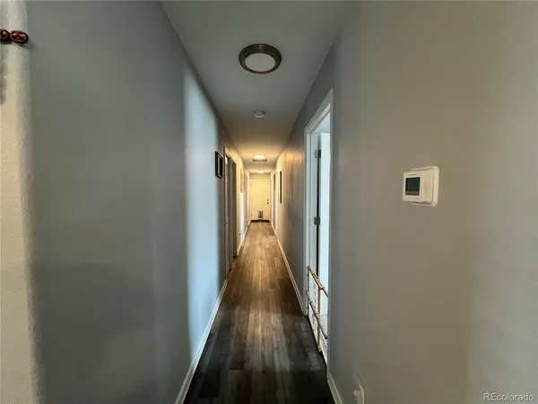 a view of a hallway with wooden floor and staircase