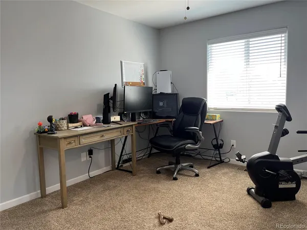a view of a workspace with furniture and a window