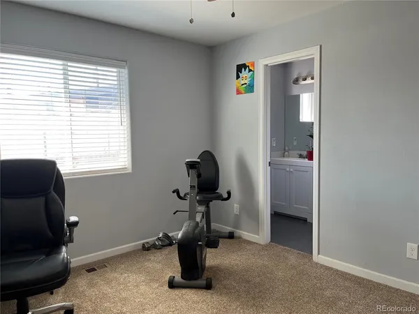 a view of a workspace with furniture and a window