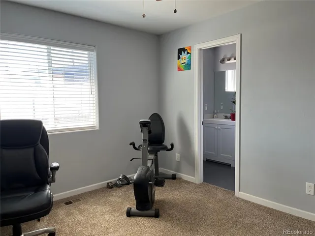 a view of a workspace with furniture and a window