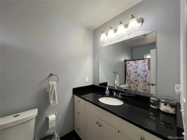 a bathroom with a granite countertop sink and a mirror