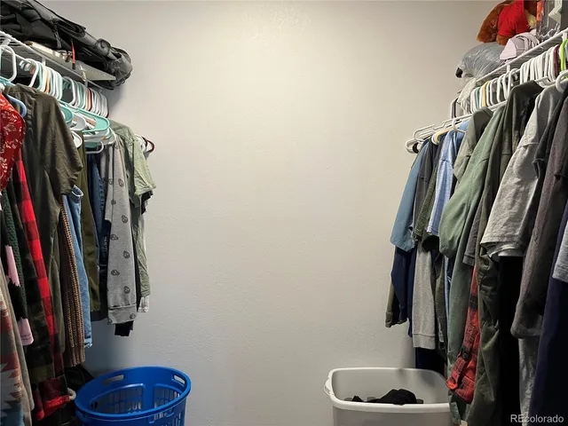 a view of walk in closet with clothes and shoes