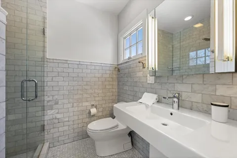 a bathroom with a toilet sink and mirror