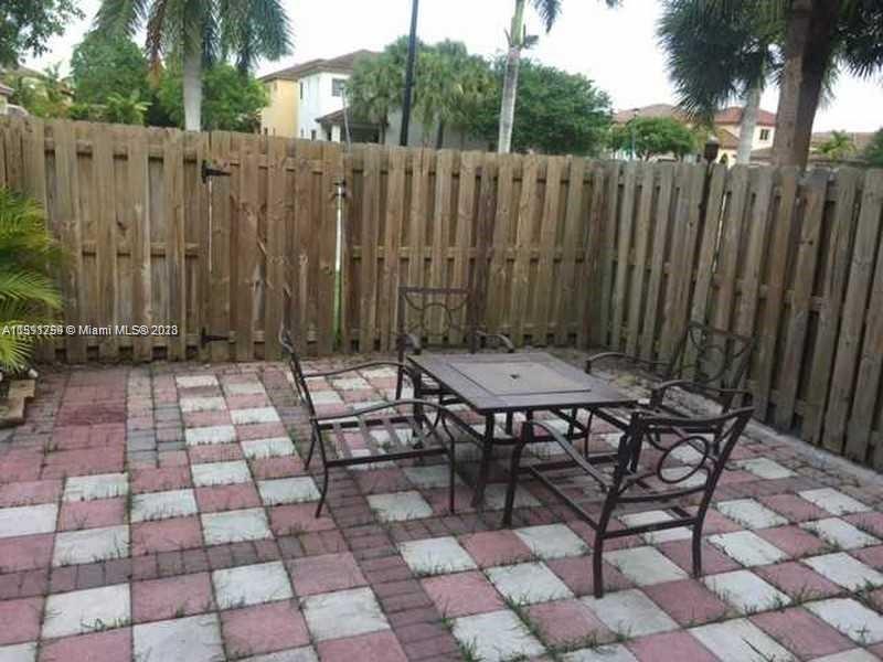 22241 Southwest 88th Path Cutler Bay, FL 33190 - Photo 6 of 9 a table and chairs in a backyard of the house