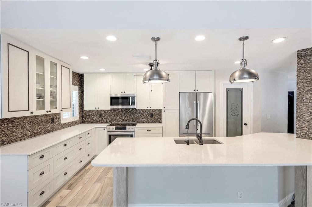 17680 Wildcat Drive Fort Myers, FL 33913 - Photo 10 of 50 a kitchen with kitchen island granite countertop a sink stove and refrigerator