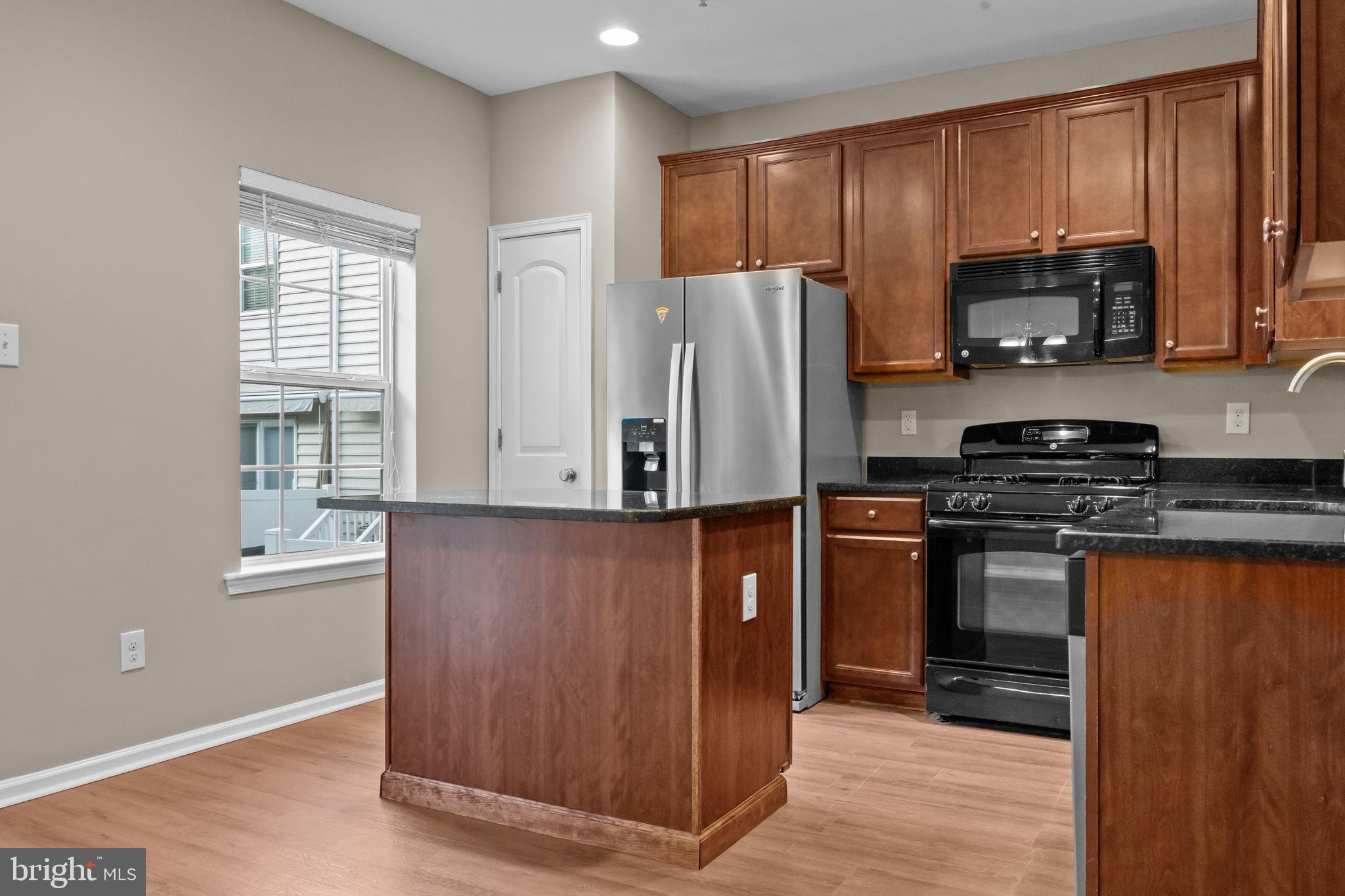 3880 Cephas Child Road, Unit 11 Doylestown, PA 18902 - Photo 7 of 34 a kitchen with stainless steel appliances granite countertop a refrigerator stove and microwave