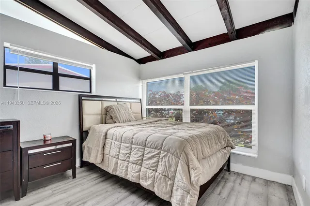 a bedroom with a bed lamp and a window