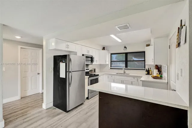 a kitchen with stainless steel appliances a refrigerator stove microwave and sink
