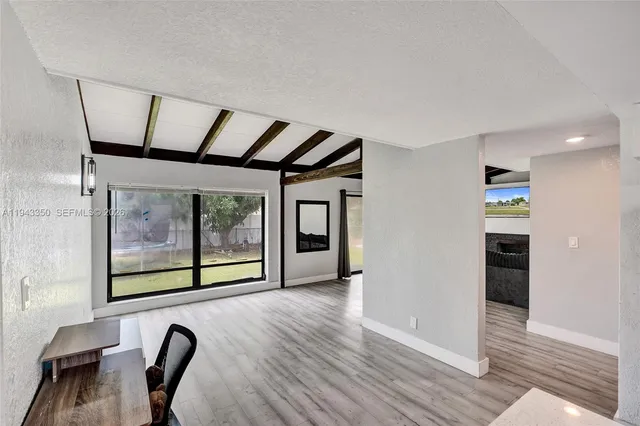 a view of a hallway with furniture and wooden floor