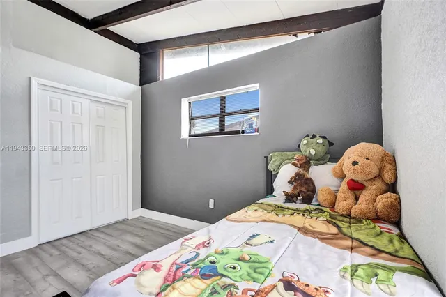 a bedroom with a bed and wooden floor