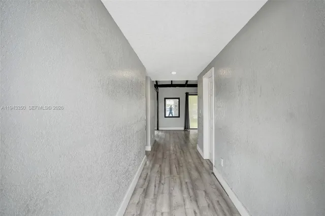 a view of a hallway with wooden floor