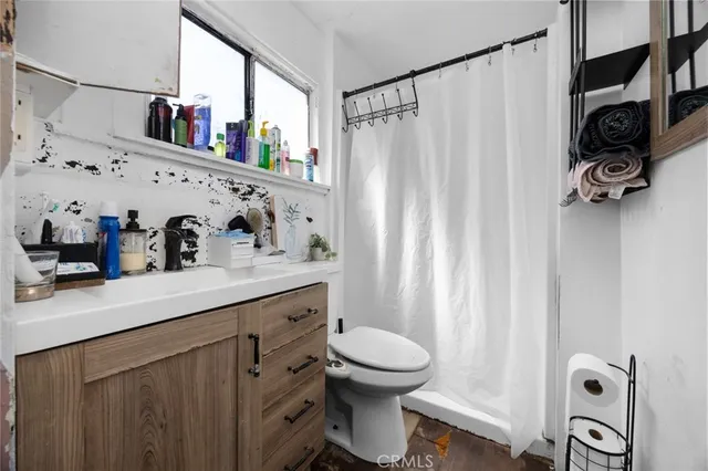 a bathroom with a sink a toilet and shower curtain