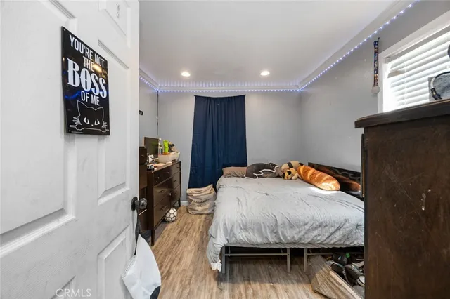 a bedroom with a bed and wooden floor