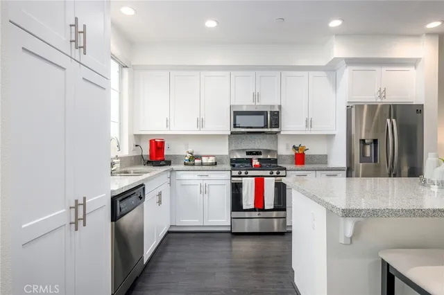 a kitchen with stainless steel appliances granite countertop a sink and dishwasher with wooden floor
