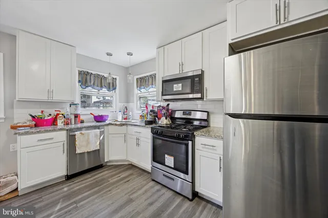 a kitchen with a sink stainless steel appliances and white cabinets