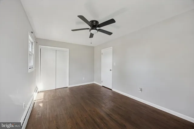 a view of a room with wooden floor and a ceiling fan