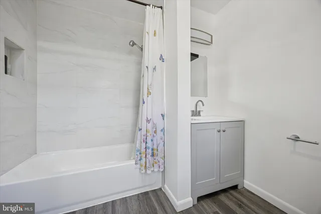 a bathroom with a bathtub a shower and a sink